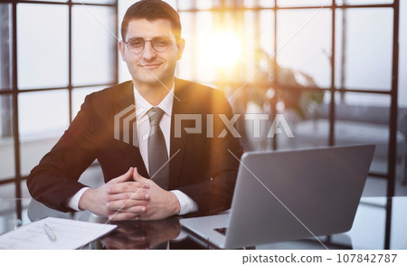 Business man thinking at laptop in office for startup management, strategy and agency. Business man thinking at laptop in office for startup management, strategy and agency. 107842787