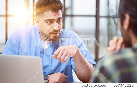 Doctor talking to a patient in a consultation at the office Doctor talking to a patient in a consultation at the office 107843226