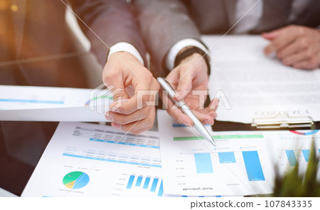 Businessman working at office desk, he is building a growing financial graph using wooden toy blocks. Businessman working at office desk, he is building a growing financial graph using wooden toy blocks. 107843335
