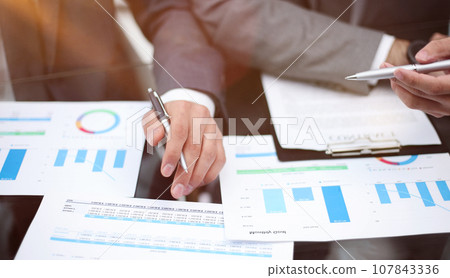 Businessman working at office desk, he is building a growing financial graph using wooden toy blocks. Businessman working at office desk, he is building a growing financial graph using wooden toy blocks. 107843336