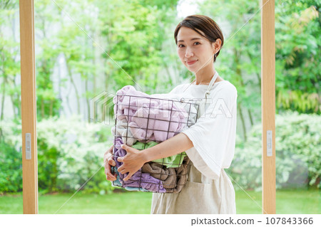 A woman with a washing basket A woman with a washing basket 107843366