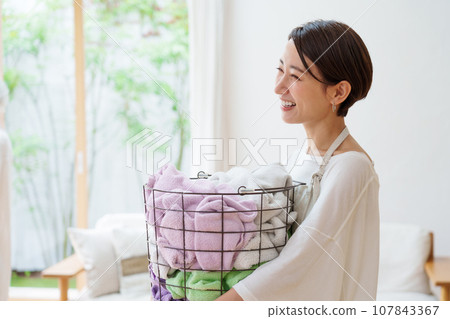 A woman with a washing basket A woman with a washing basket 107843367