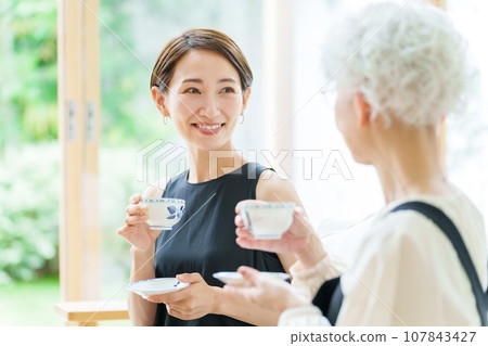 家長和孩子在客廳喝茶 家長和孩子在客廳喝茶 107843427