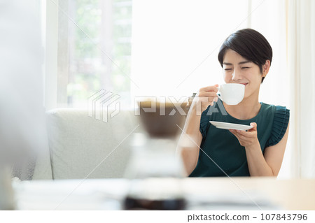 woman drinking coffee in the living room woman drinking coffee in the living room 107843796