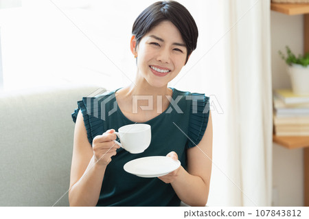woman drinking coffee in the living room 107843812