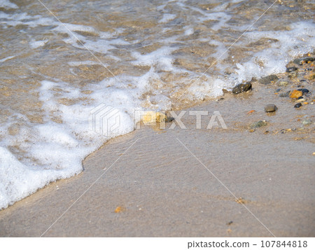 平靜清澈的大海中的沙灘岸邊。 平靜清澈的大海中的沙灘岸邊。 107844818