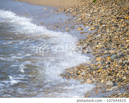 Waves crashing against the beach. 107844828