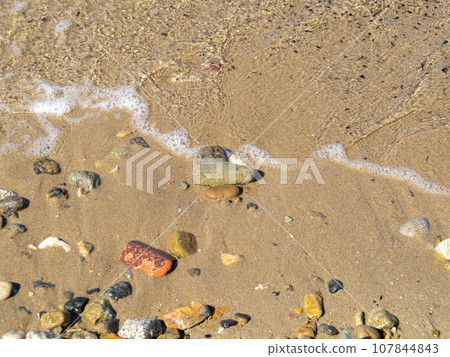 Close-up of the beach on the sandy beach of the crystal clear sea. Close-up of the beach on the sandy beach of the crystal clear sea. 107844843