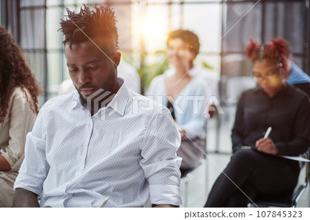 A close-up of sitting in a board room, making notes. A close-up of sitting in a board room, making notes. 107845323
