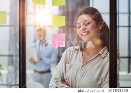 Smiling business woman looking out the window. 107845369