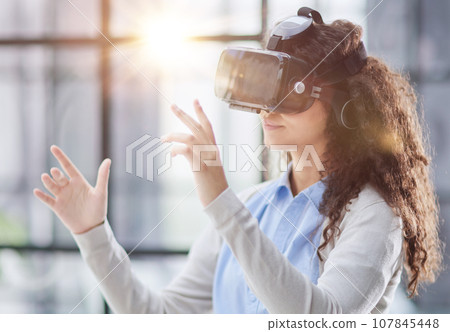 positive woman wearing virtual reality goggles headsetConnection, technology, new generation, progress concept. positive woman wearing virtual reality goggles headsetConnection, technology, new generation, progress concept. 107845448