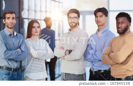 Group of successful businesspeople standing in row and looking at camera at office Group of successful businesspeople standing in row and looking at camera at office 107845539