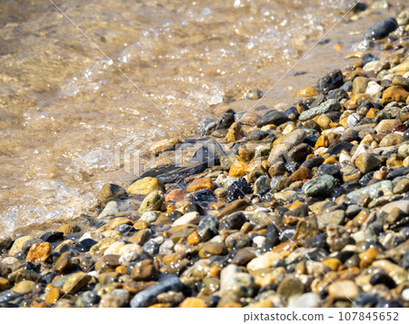 Waves on a stony sandy beach. 107845652