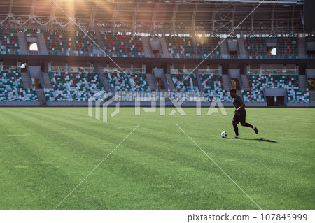 Professional football player in action at the stadium. Professional football player in action at the stadium. 107845999