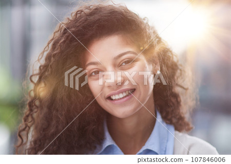 Cheerful girl standing at modern office looking at camera 107846006