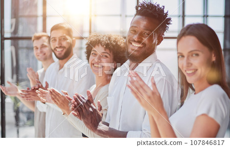 Group of businesspeople sitting in a line and applauding. Group of businesspeople sitting in a line and applauding. 107846817