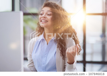 Emotional girl surprised with getting victory in online contest reading news from laptop computer 107846818
