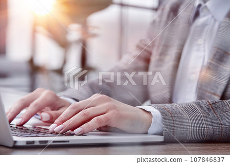Person typing on laptop keyboard, businessman working on laptop 107846837