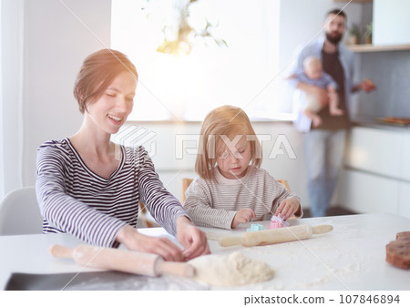 Young parents playing with children in the kitchen 107846894
