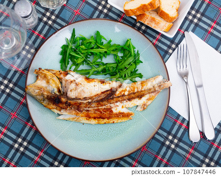 Fresh baked fish sea bass with arugula 107847446