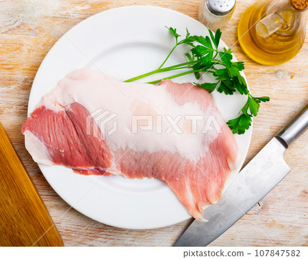 Plate of raw slice of Iberian pork secret and seasonings Plate of raw slice of Iberian pork secret and seasonings 107847582