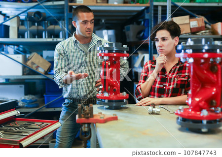 Woman fixing and assembling plumbing fixture in workshop 107847743
