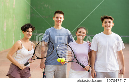 Group photo of positive young men and women standing on frontenis court after game 107847747