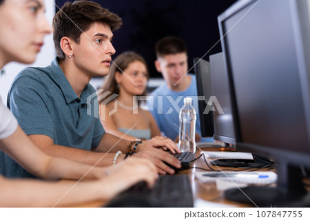 Concentrated junior software developer working in IT startup Concentrated junior software developer working in IT startup 107847755