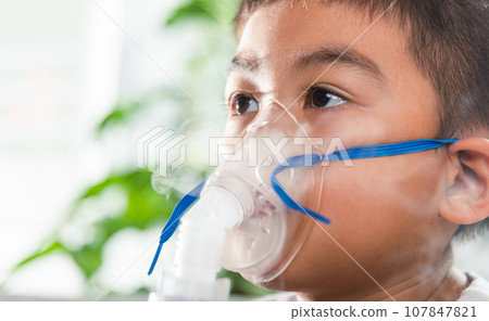 Asian Child using nebulizer mask equipment alone have smoke, Kid boy making makes inhalation nebulizer steam sick cough at home, oxygen spray inhaler therapy, stuffy nose and runny, Health medical Asian Child using nebulizer mask equipment alone have smoke, Kid boy making makes inhalation nebulizer steam sick cough at home, oxygen spray inhaler therapy, stuffy nose and runny, Health medical 107847821