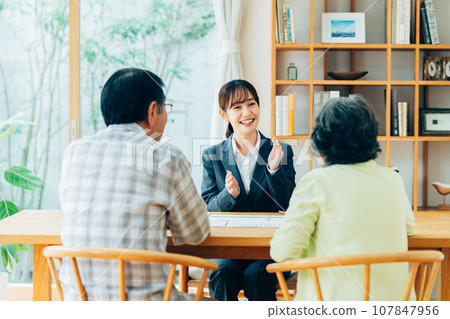 A young businesswoman working with a senior couple 107847956