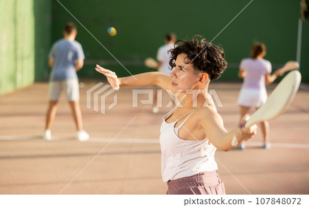 Woman serving ball during frontenis game outdoors 107848072