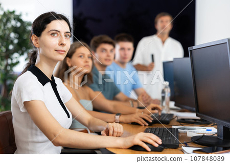 Focused girl listening to lecture during group software development course 107848089
