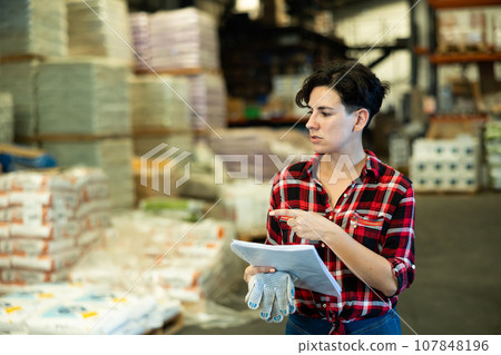 Woman checking documentation in warehouse 107848196