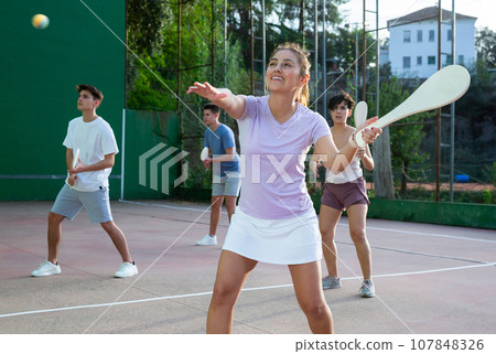 Young Argentinian woman playing pelota at open-air fronton in summer Young Argentinian woman playing pelota at open-air fronton in summer 107848326