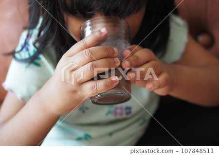 child drinking tasty chocolate milk at home. 107848511