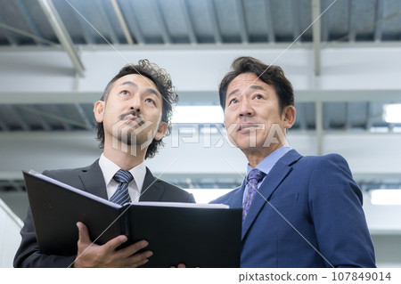 Businessman holding documents such as real estate, customers and sales, etc. 107849014