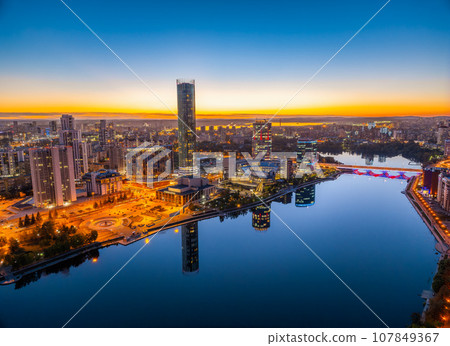 Yekaterinburg city and pond aerial panoramic view at summer or early autumn night. Night city in the early autumn or summer. Yekaterinburg city and pond aerial panoramic view at summer or early autumn night. Night city in the early autumn or summer. 107849367