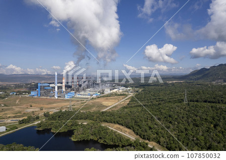 Thick white smoke from industrial factory old rusty chimneys on a cloudy grey sky background 107850032