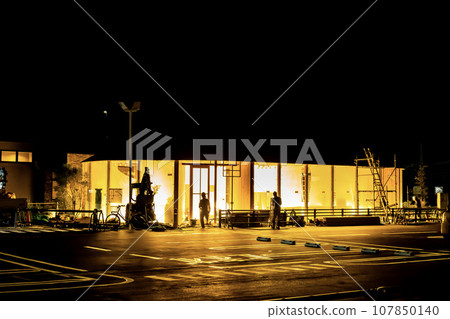 Construction site at night where finishing work is being carried out on the store before it opens. 107850140