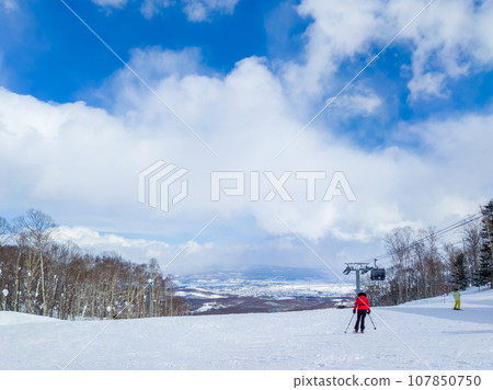 Skiers skiing on a quiet wide slope (Niseko, Hokkaido) 107850750