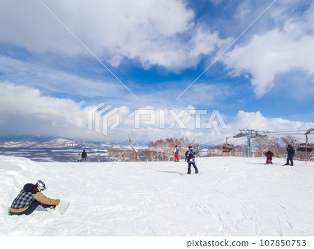 People skiing on the slopes on a sunny day (Niseko, Hokkaido) 107850753