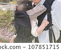 Holding a baby with cherry blossom petals 107851715