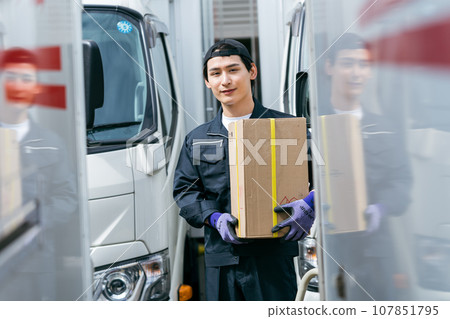 young man standing in front of a truck young man standing in front of a truck 107851795