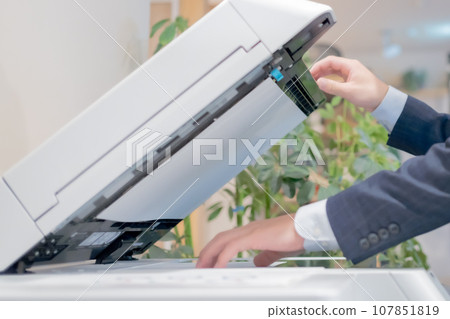 年輕人站在影印機前,不露面 年輕人站在影印機前,不露面 107851819