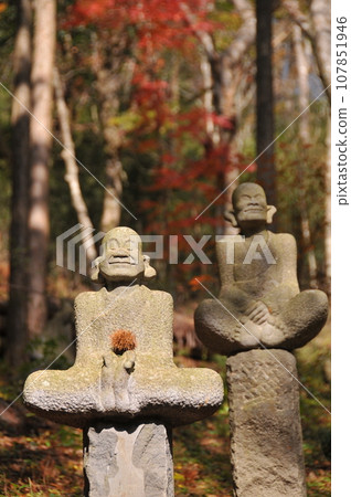 Jizo statue with autumn leaves in the background 107851946