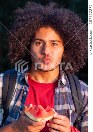 Arabian Man Enjoying Watermelon at Sunset Arabian Man Enjoying Watermelon at Sunset 107852272