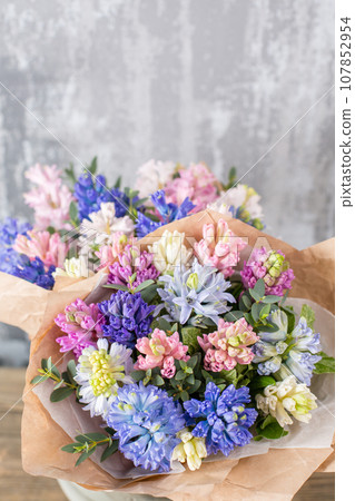 Small Beautiful bouquet of mixed flowers in woman hand. Floral shop concept . Beautiful fresh cut bouquet. Flowers delivery 107852954