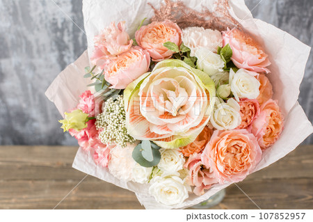 Small Beautiful bouquet of mixed flowers in woman hand. Floral shop concept . Beautiful fresh cut bouquet. Flowers delivery 107852957