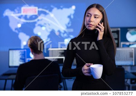 Female Cybersecurity Manager talking in the phone in Enterprise Cyber Security Operations Center SOC Female Cybersecurity Manager talking in the phone in Enterprise Cyber Security Operations Center SOC 107853277