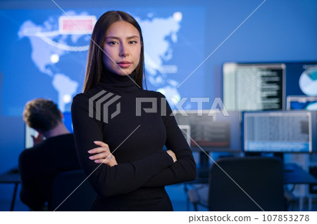 Female Cybersecurity Analyst or Manager in large Cyber Security Operations Center SOC handling Threats 107853278